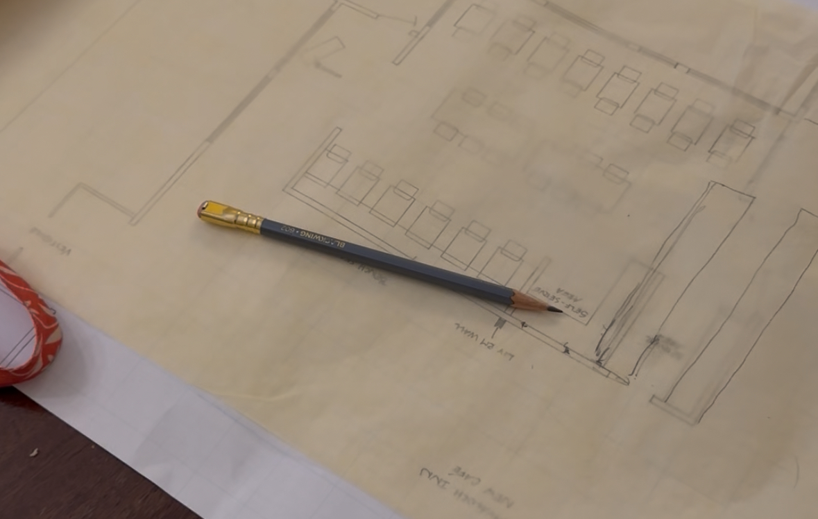 A Blackwing pencil lies atop tracing paper lying atop blueprints for our renovations